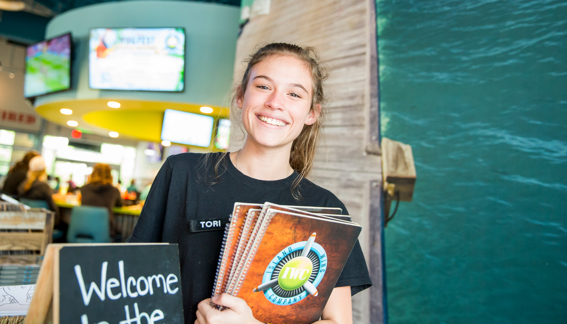Waitress with a menu smiling at Island Wing Company